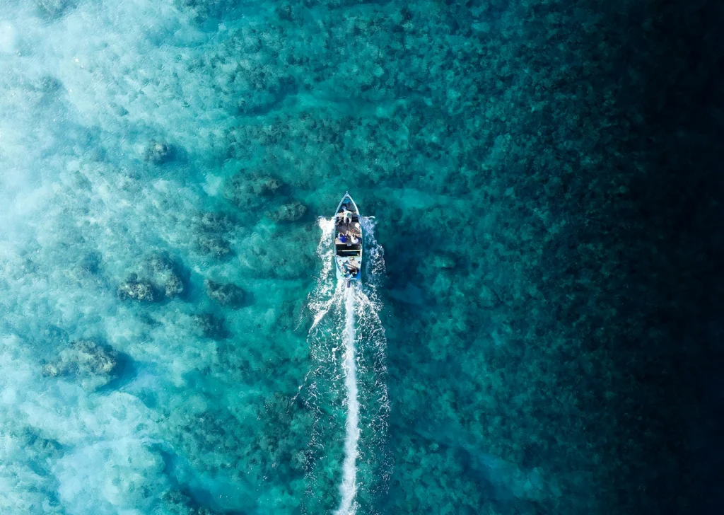 Aerial view of a speedboat cutting a wake across blue ocean