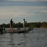 Two anglers working the deck of a boat offshore