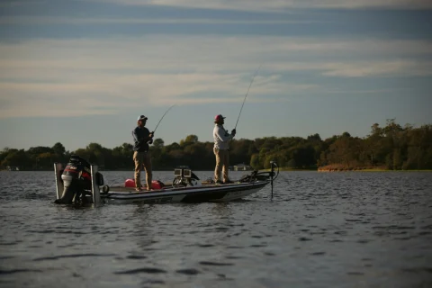Two anglers working the deck of a boat offshore